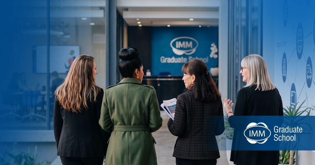 Bronwyn Strydom, Kershnee Hermanus, Marzia Storpioli, and Jacqui Deeks walking together in discussion towards the IMM Graduate School reception desk.